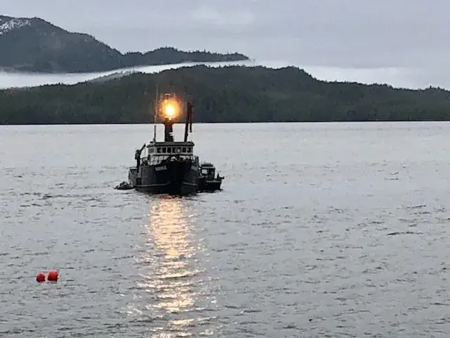 A work boat on the water at dawn near the farm site